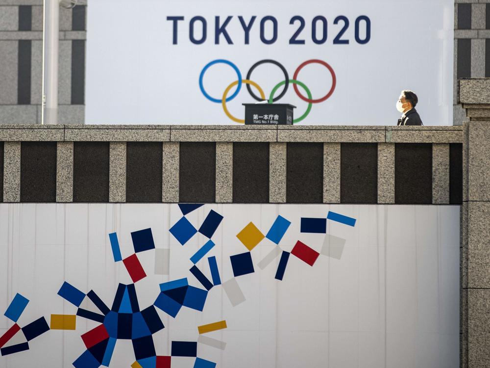 A pedestrian walks past an official Tokyo 2020 Olympic Games banner hanging on the Tokyo Metropolitan Government Building on Friday.