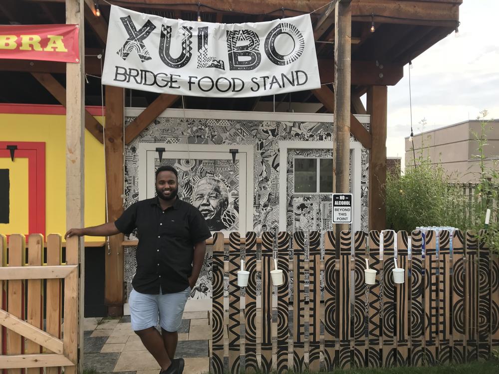 Mustafa Nuur stands outside of his family's food stand in Lancaster, Pa. He helps newly arrived refugees settle in the area.