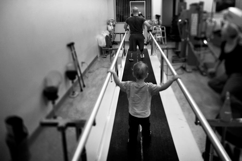 Liam, 2, accompanies his dad, Jake Romo, during rehab at the Naval Medical Center in San Diego. Romo, 22, lost both his legs while serving with the 3rd Battalion, 5th Marines, in Sangin, Afghanistan. <em>From the story 