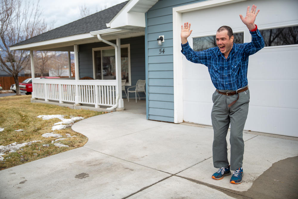 Domier waves to other residents of his group home as they leave the driveway.