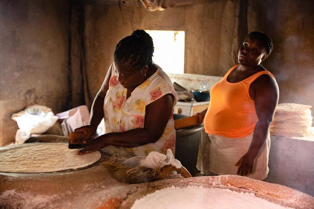 Ella watches her mother Tomasa spread freshly milled yucca flour over a wood-fired stove to make <em>ereba</em>, a traditional flatbread.