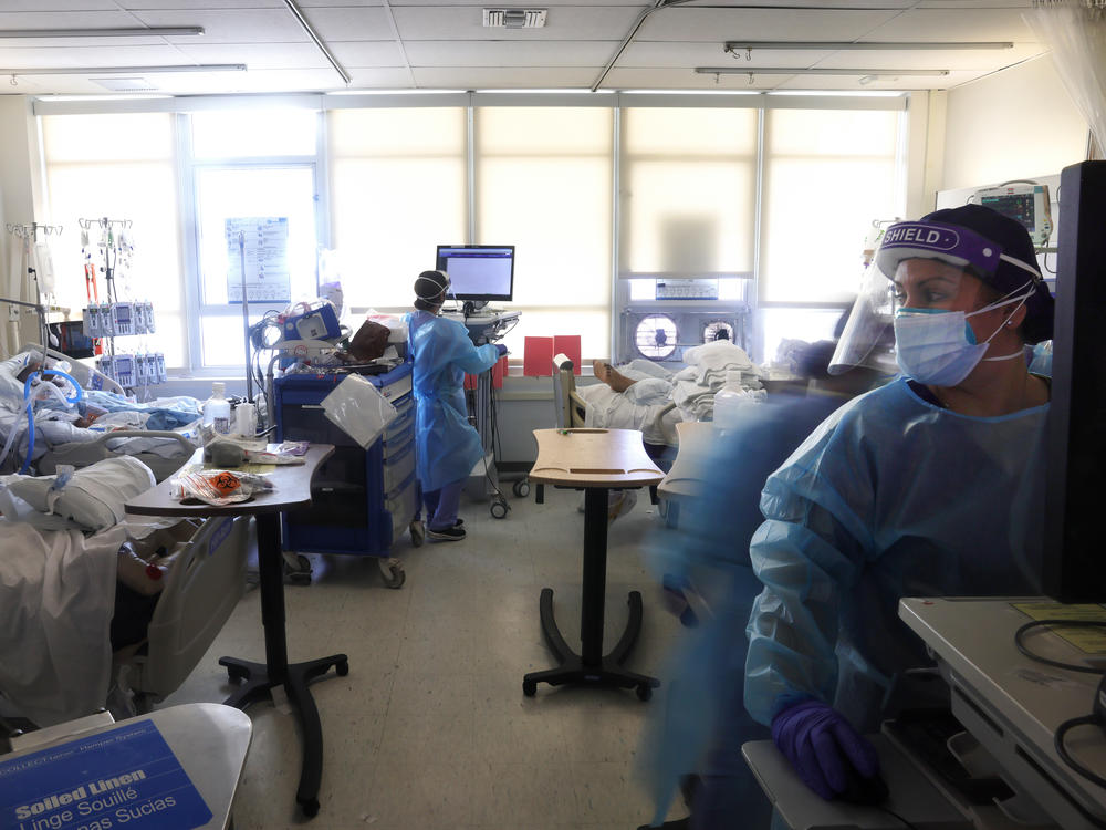 Clinicians care for COVID-19 patients last week in a makeshift intensive care unit at Harbor-UCLA Medical Center in Torrance, Calif. California is lifting regional stay-at-home orders, but county and local authorities can keep other restrictions in place.