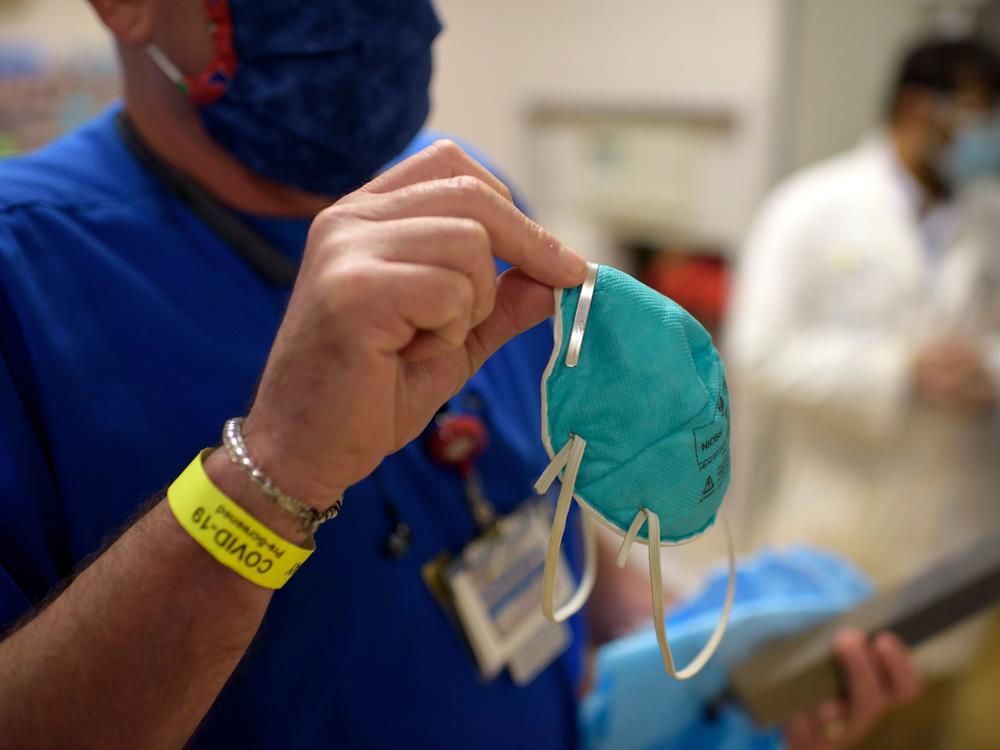 A health worker holds an N95 respirator in the emergency room at OakBend Medical Center in Richmond, Texas, in July. N95s are tested and approved by a federal agency as having demonstrated that they can filter out a minimum of 95% of airborne particles.