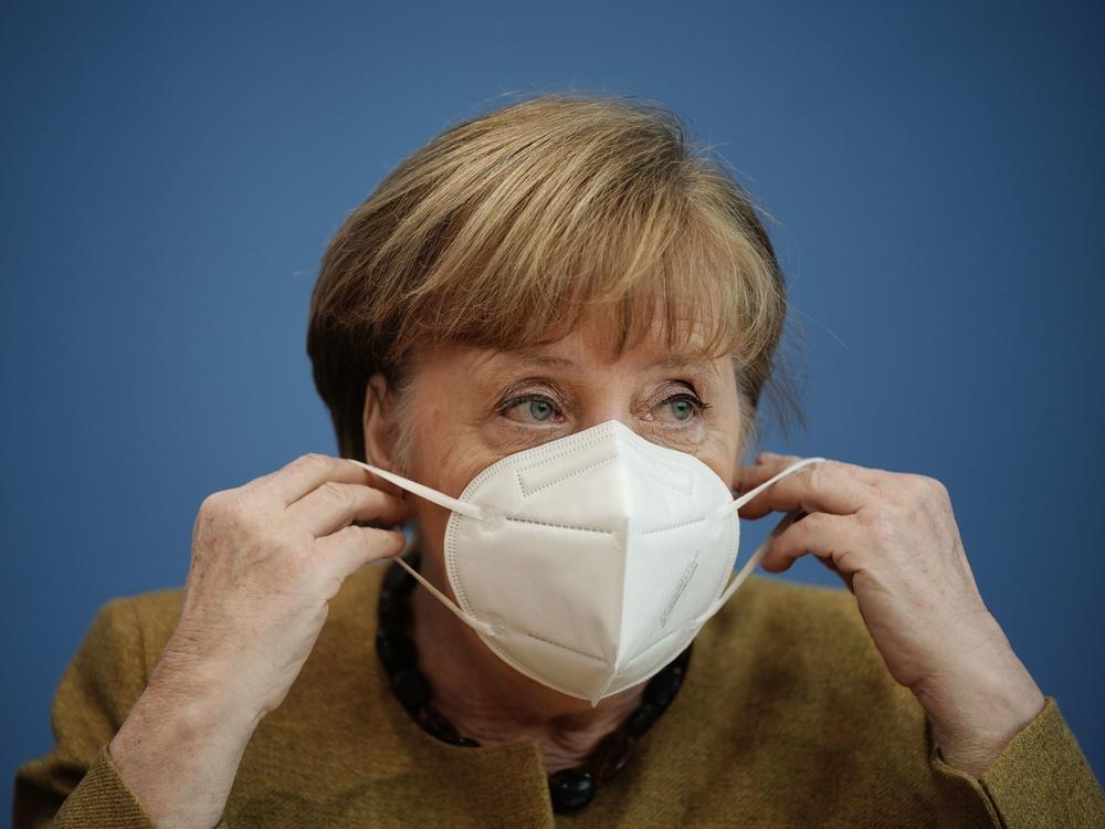 German Chancellor Angela Merkel puts on her face mask after a news conference in Berlin last week. Germany has introduced new requirements for medical-grade masks to be worn on public transit and in shops.