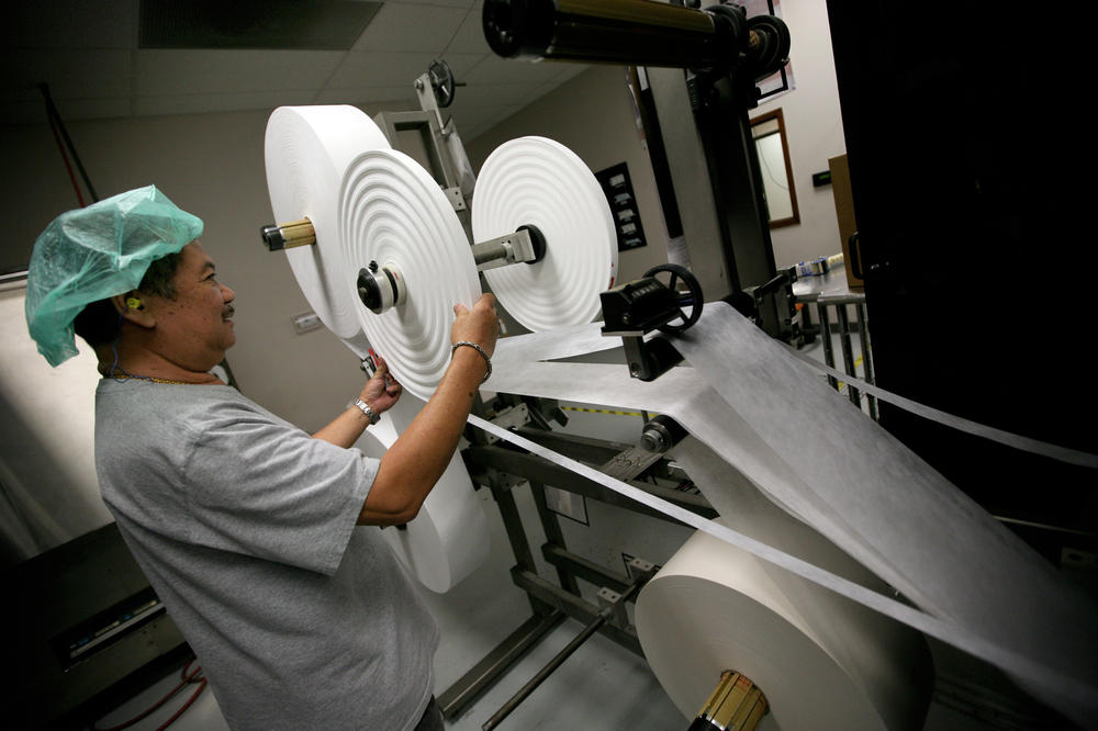 Prestige Ameritech employee Saengdara Phanvilay, pictured during the 2009 swine flu outbreak, inspects a machine that produces disposable surgical masks.