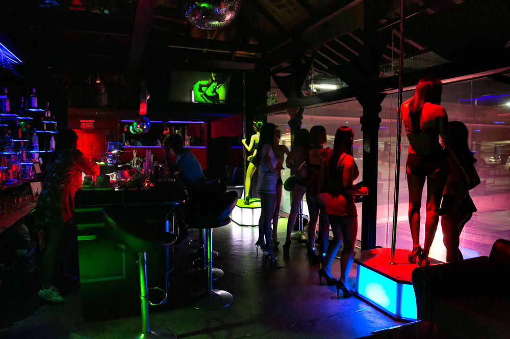 Working in the bars of the red-light district pays more than many office jobs or other service work that the women and men in Thailand's sex industry would otherwise qualify for. Above: Women dance at a bar in the Patpong red-light district in Bangkok.