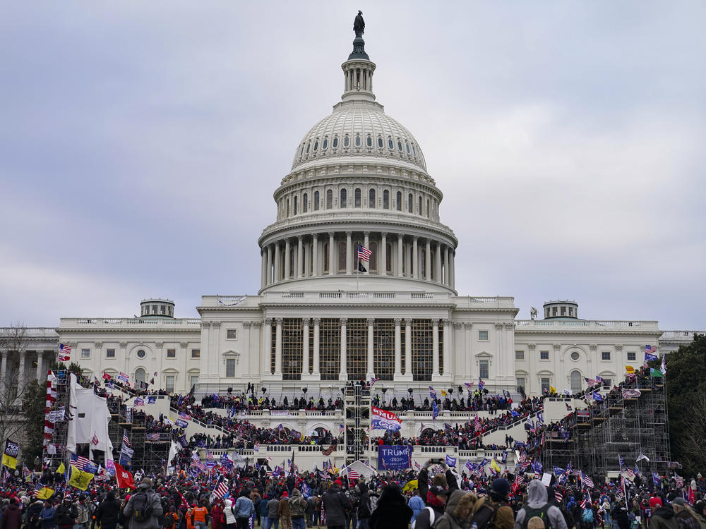 Rioters storm the Capitol on Jan. 6. Three individuals associated with an extremist group were indicted Wednesday on charges that include conspiracy and obstructing an official proceeding.