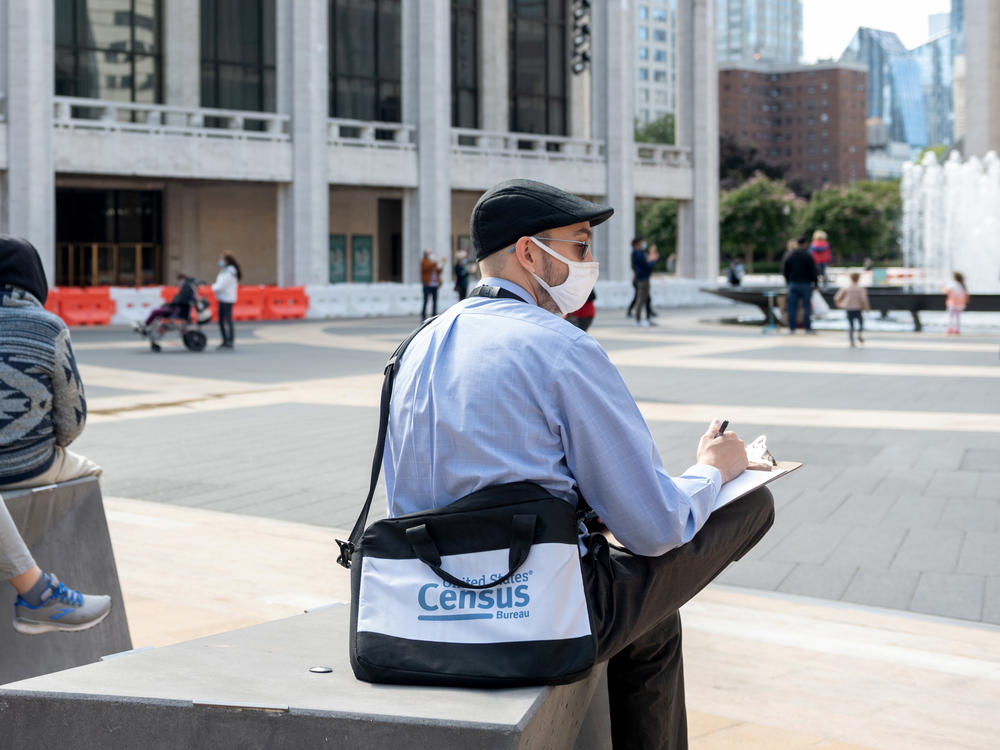 A U.S. census worker sits in the plaza of the Lincoln Center for the Performing Arts in New York City in September. The Census Bureau announced Wednesday that the first results of the 2020 census are expected to be released by April 30.