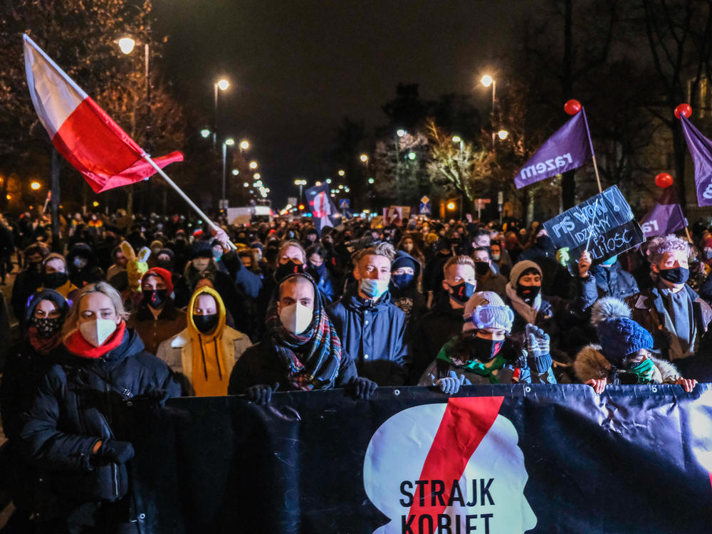 Protesters against new restrictions on abortion walk toward the Law and Justice Party headquarters on Wednesday night in Warsaw. A Constitutional Court ruling in October determined that abortions are only legal in cases of rape and incest, and when the mother's health or life is in danger.