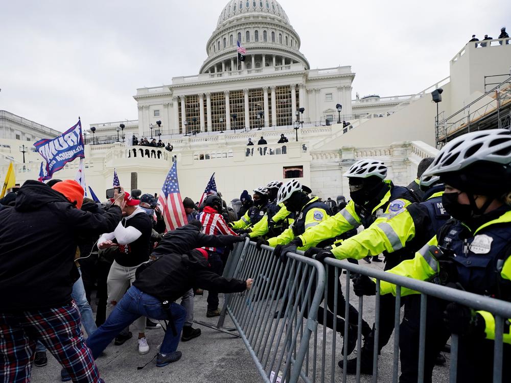 In this Wednesday, Jan. 6, 2021 file photo, Trump supporters try to break through a police barrier at the Capitol in Washington, D.C.