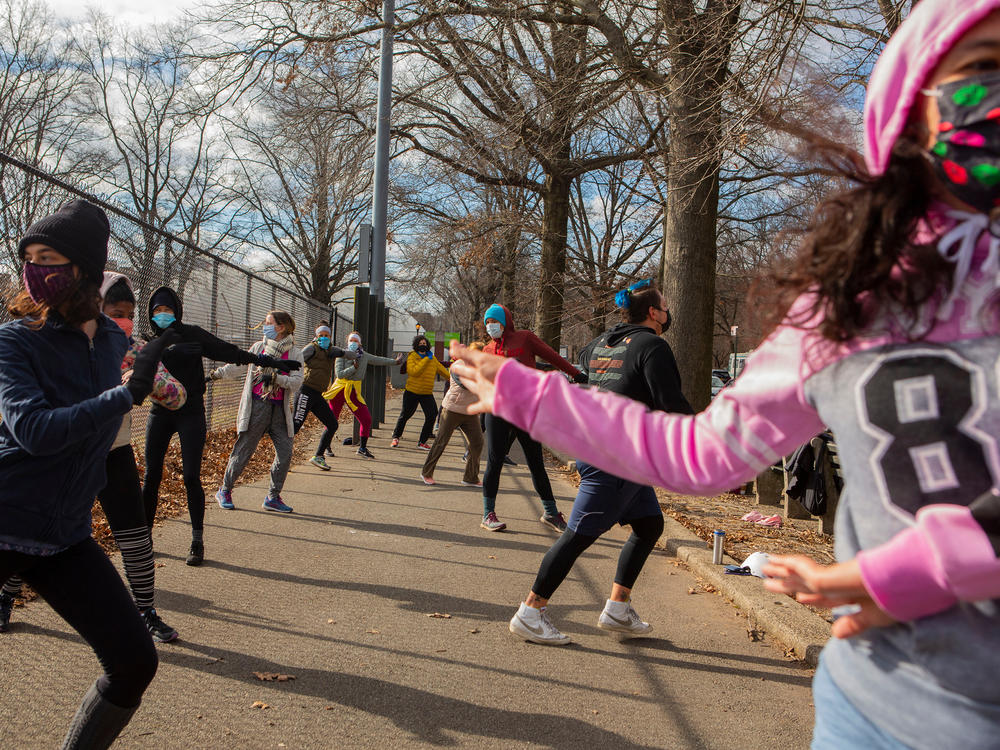 Michael Aredes teaches a Zumba class outside Prospect Park in  Brooklyn. About 10 women bundled up to join the socially distant exercise class on a recent Saturday.