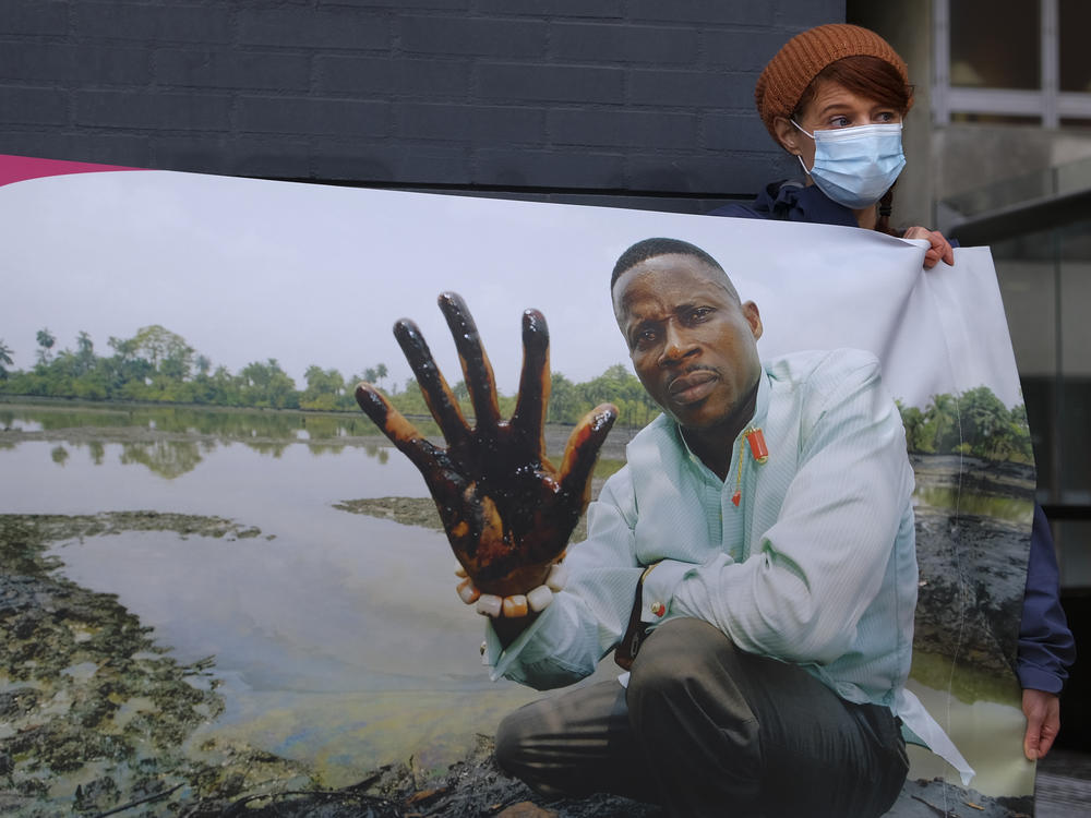 Friends of the Earth supporters unfold a banner on Friday outside the district court in The Hague, Netherlands, where the court delivered its judgment in a long-running case in which four Nigerian farmers are seeking compensation and a cleanup from energy giant Shell for pollution caused by leaking oil pipelines in the Niger Delta.