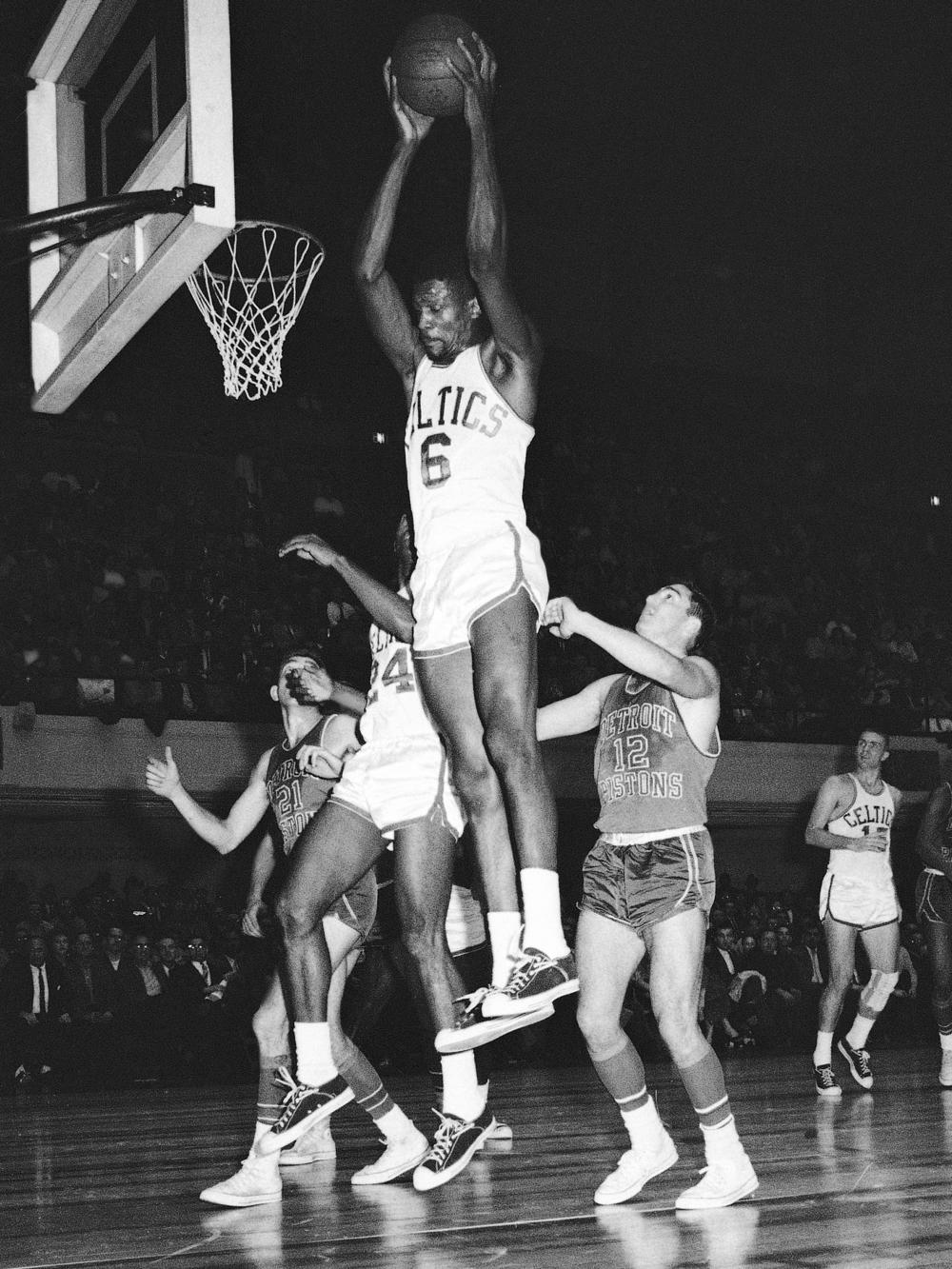 Russell soars to grab a rebound against the Detroit Pistons in 1961. Russell revolutionized basketball with his high-flying defense and prolific shot-blocking. 