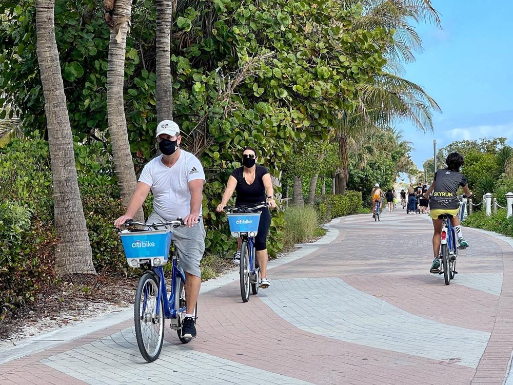 People bike along the beach in Miami on Dec. 20, 2020. 