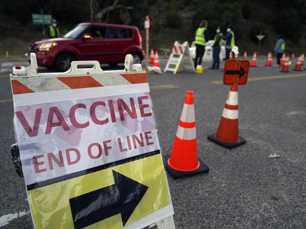 Drivers with an appointment enter a COVID-19 vaccination site set up in the parking lot of Dodger Stadium in Los Angeles on Saturday. One of the largest vaccination sites in the country, it was temporarily shut down Saturday afternoon because of protesters, stalling hundreds of motorists who had been waiting in line for hours.