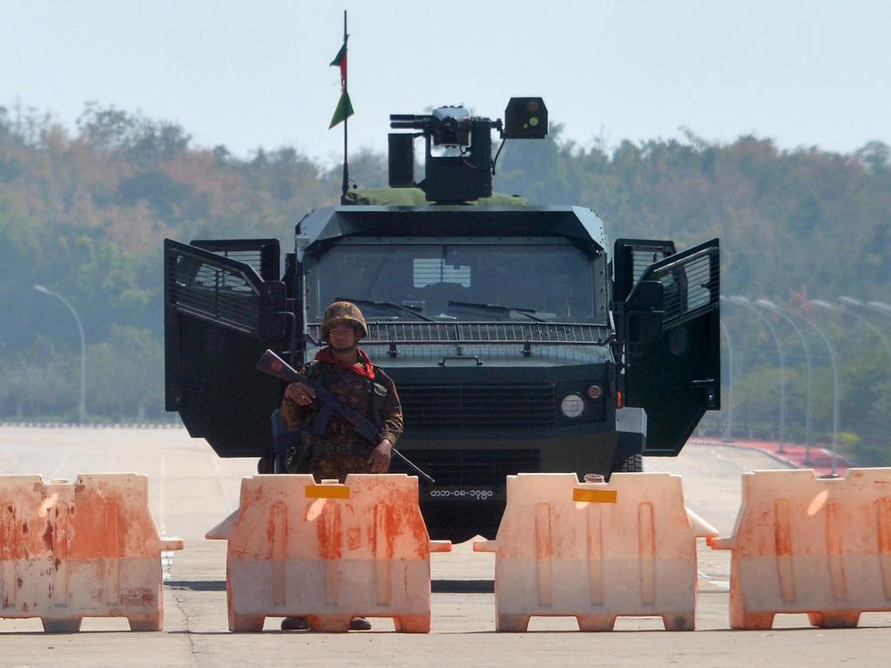 A soldier stands guard on a blockaded road to Myanmar's parliament in Naypyidaw on Monday, after the military detained the country's de facto leader Aung San Suu Kyi and other officials and activists.