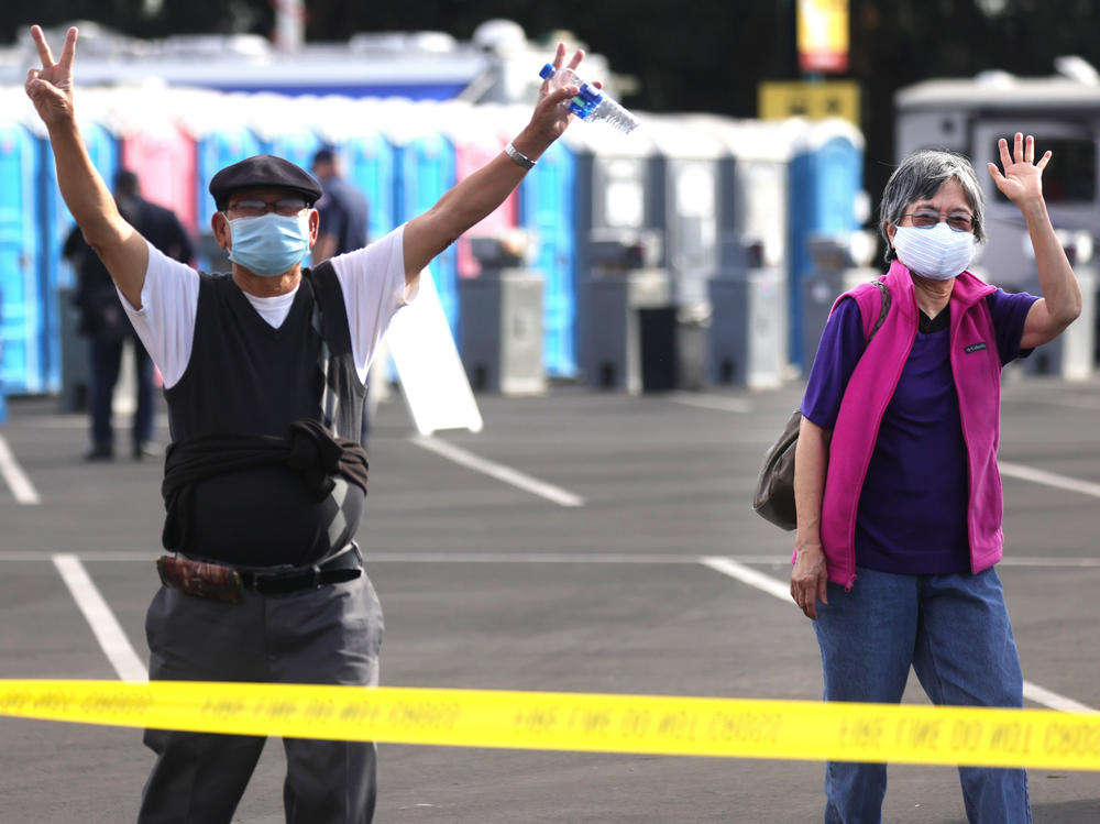 Southern Californians celebrate at a mass vaccination site in Disneyland's parking lot in January. CDC head Dr. Rochelle Walensky cautions that for strongest immunity, recipients get both doses of the Pfizer or of the Moderna vaccine.