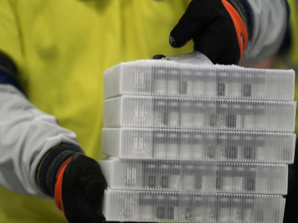 A worker carries boxes containing the Pfizer-BioNTech COVID-19 vaccine that were being prepared for shipment from a Pfizer facility in Portage, Mich., in December.
