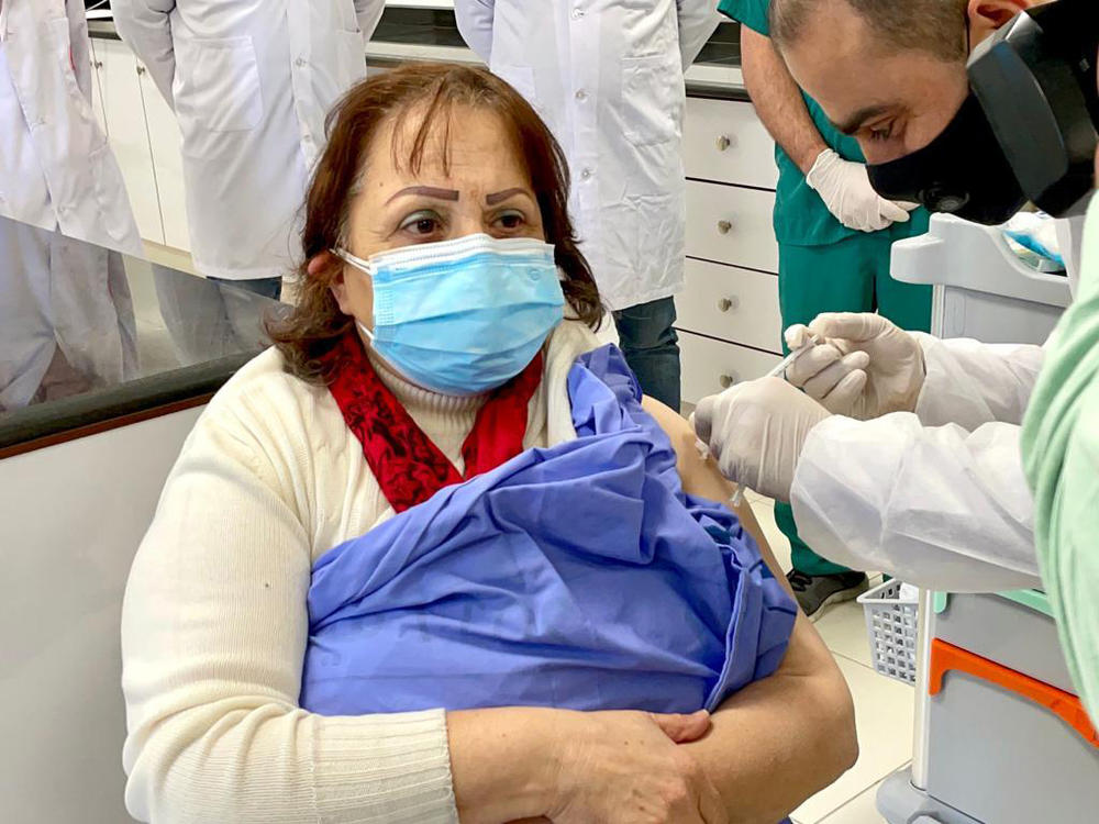 Palestinian Health Minister Mai al-Kaila receives a COVID-19 vaccination on Tuesday in a West Bank hospital.
