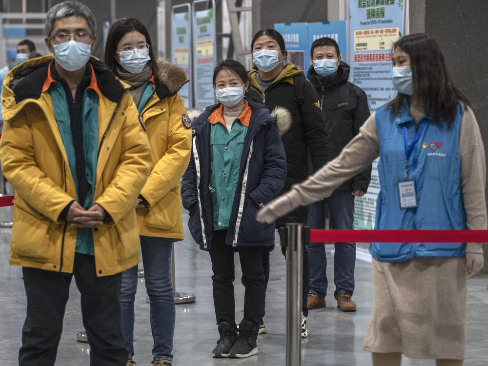 Chinese workers wait to receive a COVID-19 vaccine jab at a mass vaccination center in Beijing on Jan. 5. Even with at least 5 homegrown vaccines nearing approval, China is setting a modest initial goal: 50 million people vaccinated by mid-February — about 3.5% of the total population.