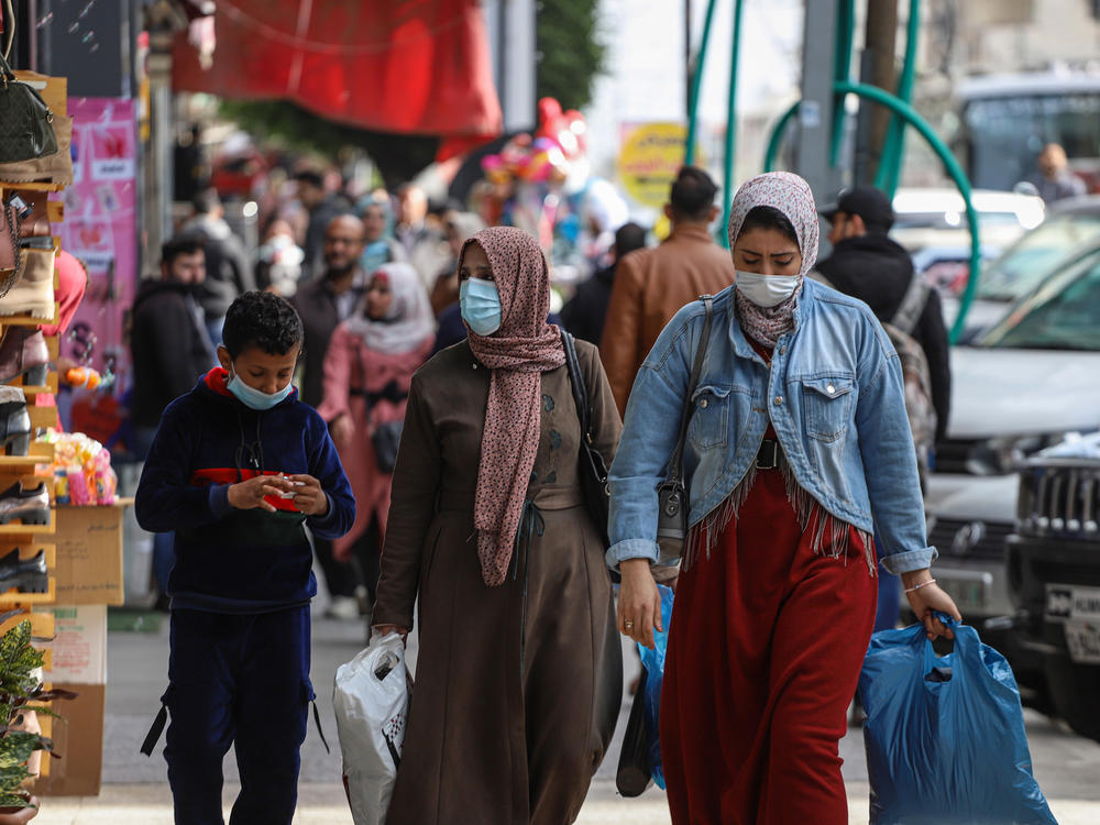 People wear face masks on a shopping street in Gaza City in January.