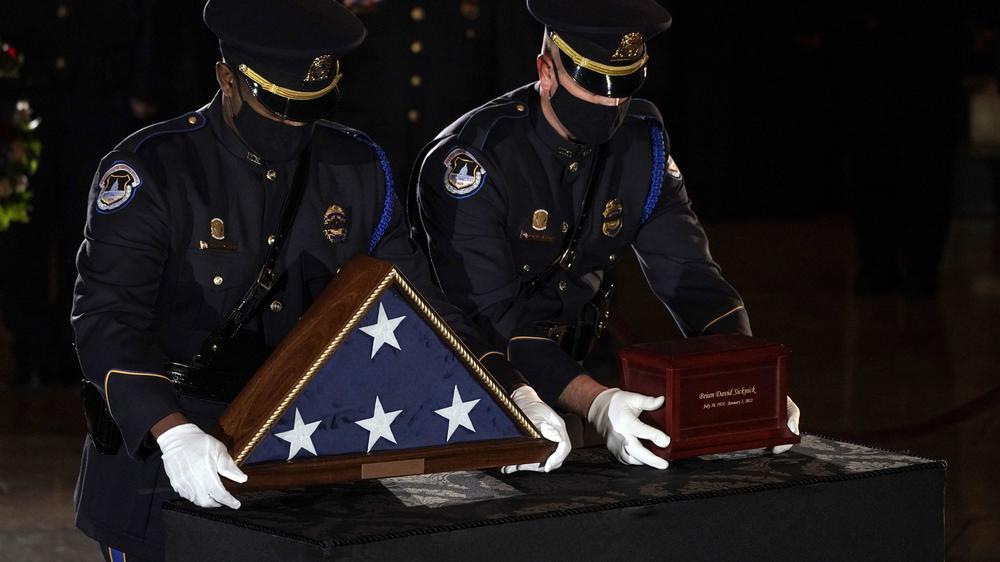 Sicknick's remains are placed next to a U.S. flag on a pedestal in the Capitol Rotunda