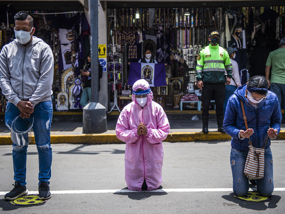Worshippers pray in the streets of Lima. A government lockdown has shutdown churches as well as businesses to try to stop the spread of the virus.