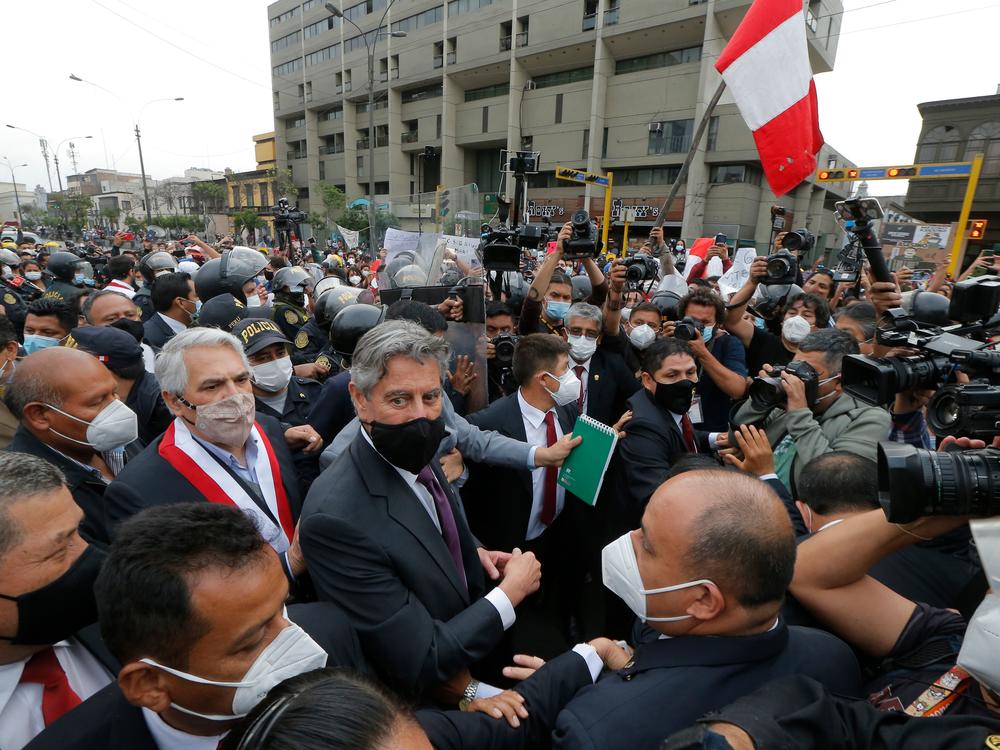 Francisco Sagasti, center with black mask, leaves the Congress in November after being chosen as the country's interim President. Sagasti was the third president in the span of a week. Political instability has hampered Peru's efforts to get vaccines.