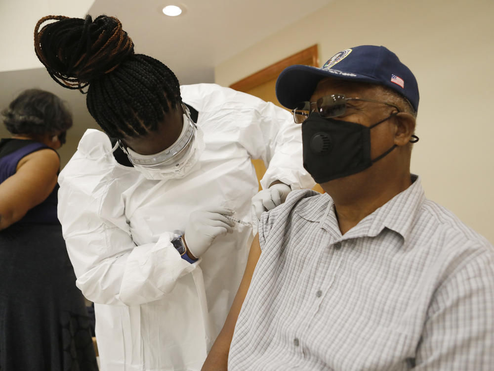 A health care worker administers the COVID-19 vaccine to a resident in Tampa, Fla., on Jan. 10. Seniors in Florida's Leon County have had trouble signing up for the vaccine and a local reporter tried to help them.