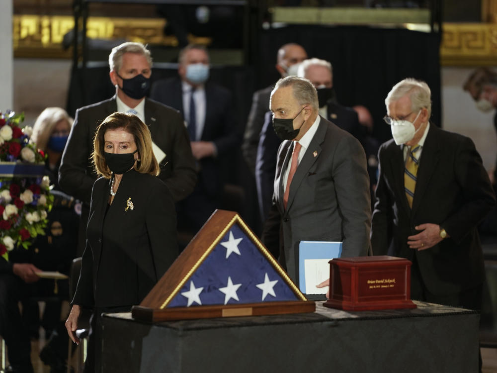 Speaker of the House Nancy Pelosi, left, and Senate Majority Leader Chuck Schumer, center, walk past the remains of U.S. Capitol Police Officer Brian Sicknick as he lies in honor in the Rotunda of the Capitol on Wednesday.