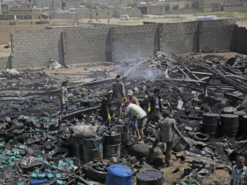 Workers salvage oil canisters from the wreckage of a vehicle oil store hit by Saudi-led airstrikes last July in Sanaa, Yemen. The U.S. said Thursday it will no longer back the Saudi-led military offensive.