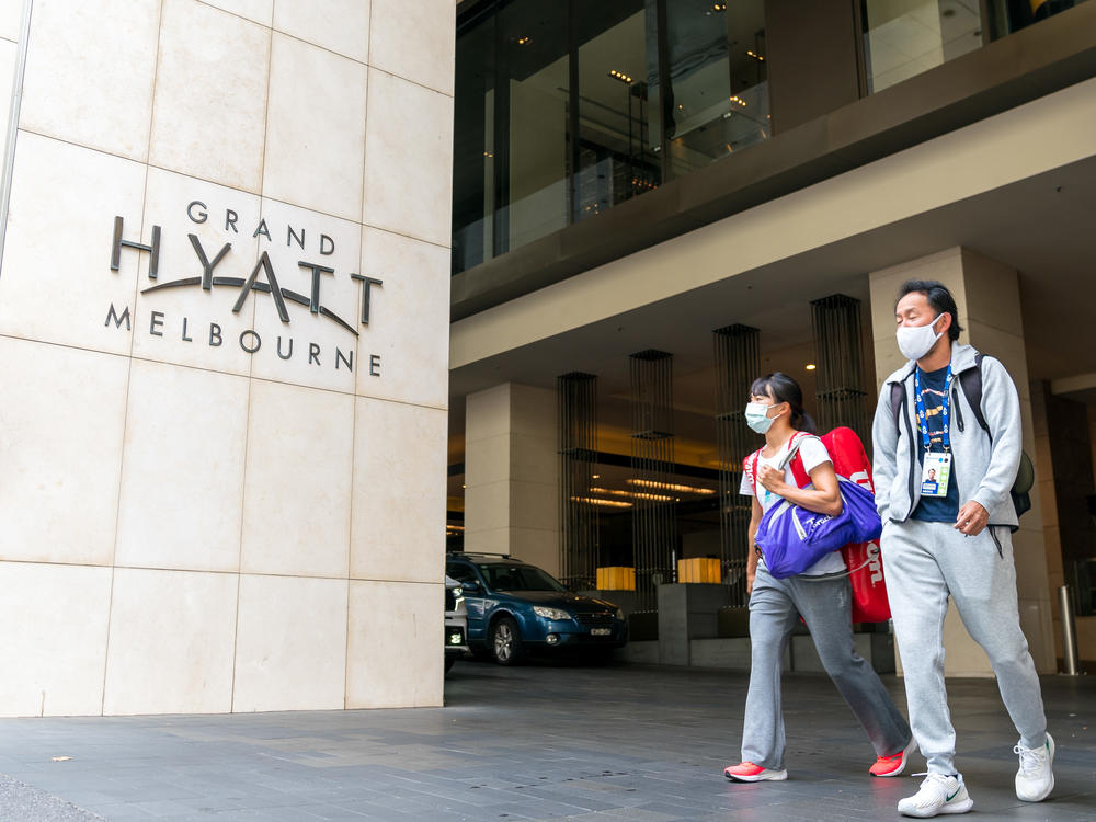 Players and their entourages emerge from the Grand Hyatt Melbourne on Thursday. A positive case was discovered at one of the Australian Open quarantine hotels, with some 500 Australian Open players, officials and support staff told to quarantine and get tested.