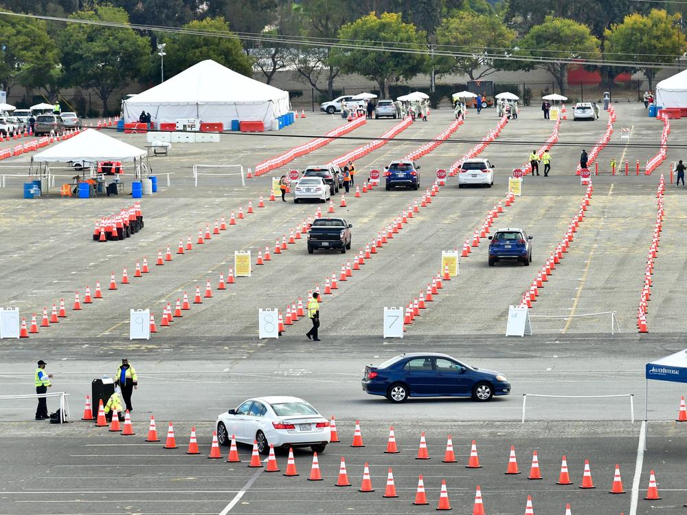 People wait for COVID-19 vaccinations in their vehicles at the Fairplex fairgrounds in Pomona, Calif., last month. The White House announced on Friday that active duty military personnel will soon be deployed to assist at vaccination sites, starting this month in California.