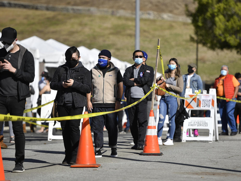 The U.S. wants at-home coronavirus testing to be widely available, to help Americans return to normal life. Here, people wait in a long line at a coronavirus testing and vaccination site at Lincoln Park in Los Angeles.