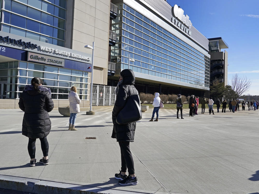 People wait in a socially distanced line to get their COVID-19 vaccinations at Gillette Stadium in Foxborough, Mass., last month. The NFL is making all 30 of its stadiums available to serve as mass vaccination sites.