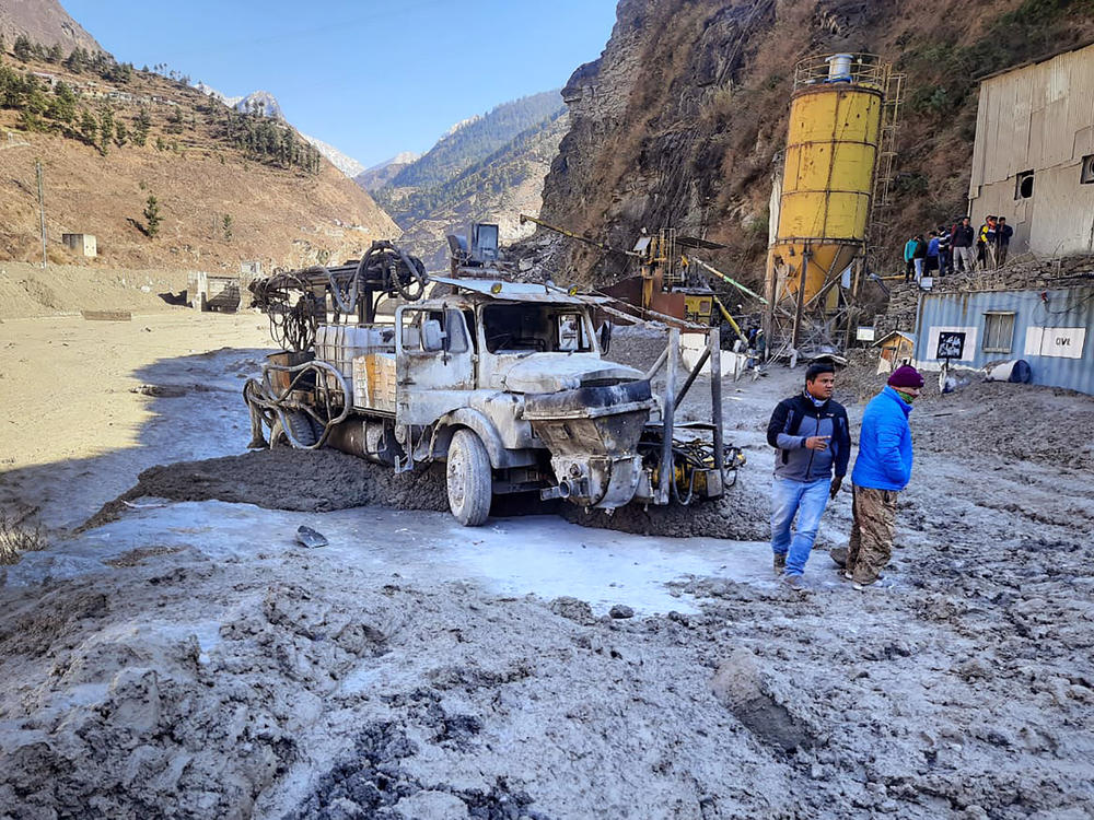 After a portion of the Nanda Devi glacier broke off in northern India on Sunday, people inspect a site near a damaged hydropower project at Reni village in Chamoli district in the country's Uttarakhand state.
