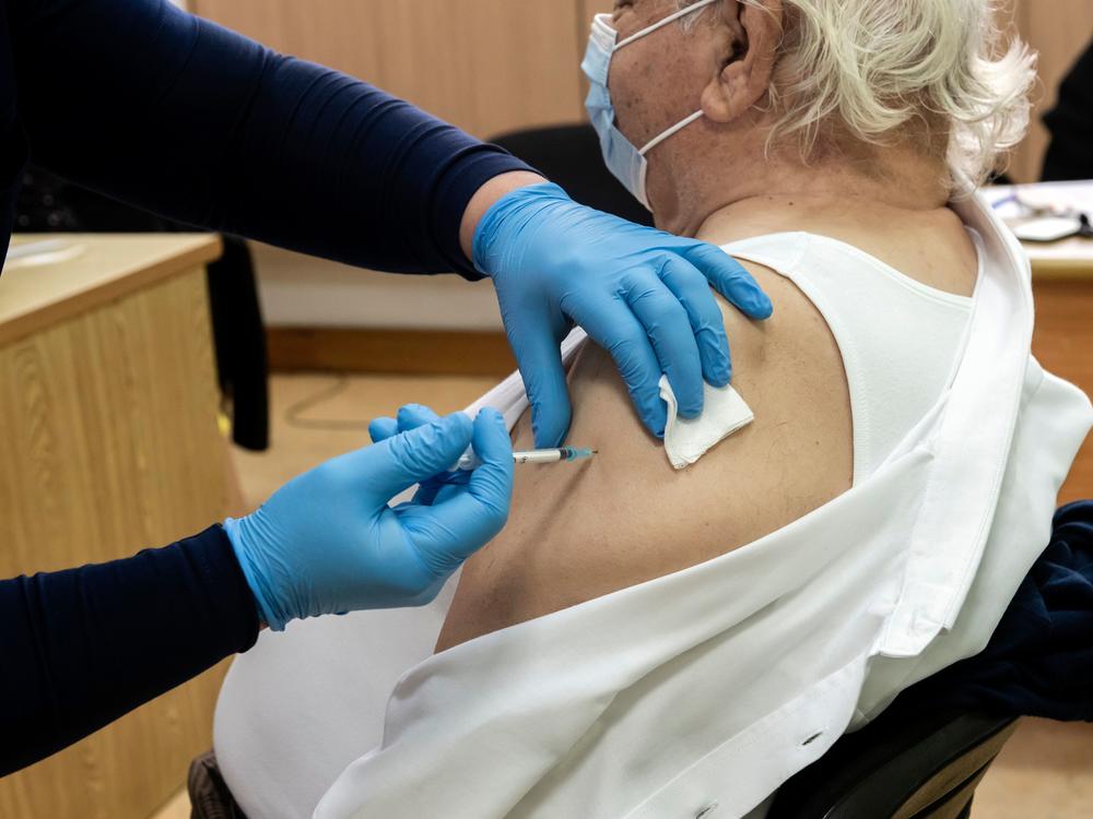 A healthcare worker administers a dose of the coronavirus vaccine to an elderly at a health center in the Cypriot coastal city of Limassol on February 8, 2021.