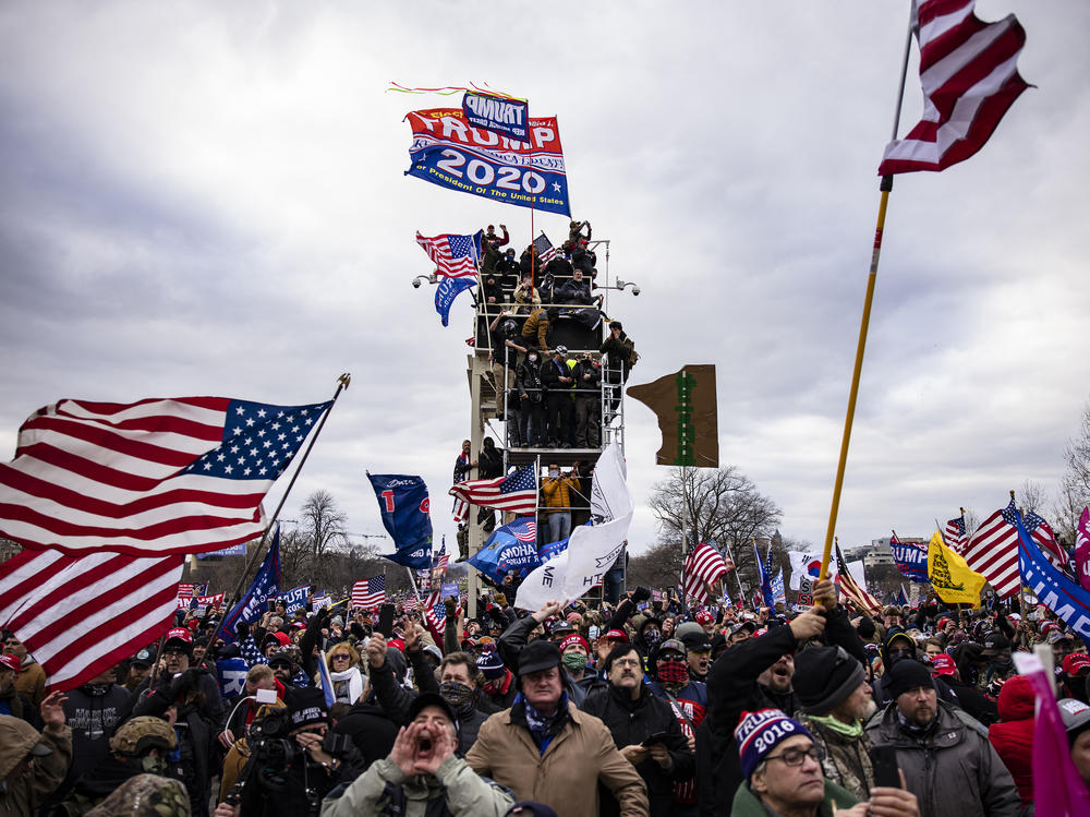 Pro-Trump supporters storm the U.S. Capitol following a rally on Jan. 6. So far, military veterans account for about 15% of those criminally charged in the Capitol riot, according to an NPR analysis.