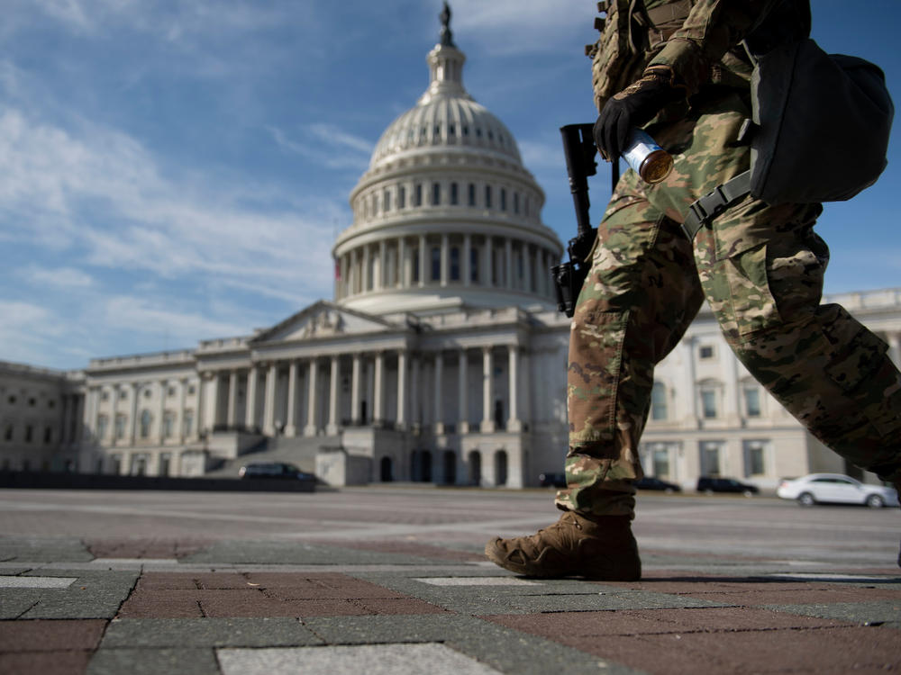 A member of the National Guard walks on Capitol Hill Tuesday, before the first day of former President Donald Trump's Senate impeachment trial.