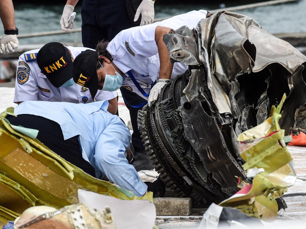 Indonesia's National Transportation Safety Committee (KNKT) officers check debris last month from the crash of a Sriwijaya Air Boeing 737-500 in  Jakarta, Indonesia.
