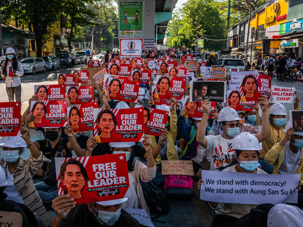 Protesters hold images of de-facto leader Aung San Suu Kyi on Wednesday in Yangon, Myanmar. As fallout from the Feb. 1 military coup continues, U.S. President Joe Biden announced plans to sanction the leaders who directed it.