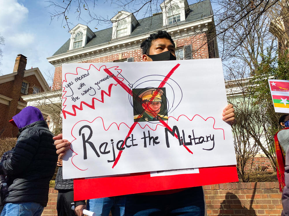 A demonstrator in Washington, D.C., protesting the recent military takeover of Myanmar's government holds a sign featuring the face of the Min Aung Hlaing, the coup leader. There have been gatherings to protest the coup in front of the Myanmar military attaché's office in Northwest D.C. nearly every day since it happened on Feb. 1.