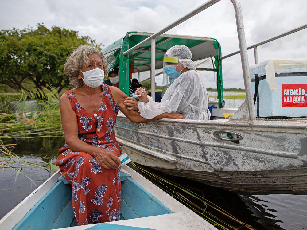 A health worker inoculates 72-year-old Olga D'arc Pimentel with a dose of Oxford-AstraZeneca's COVID-19 vaccine. She lives on the banks of the Rio Negro near Manaus, Brazil. A small study in South Africa has raised concerns about the AstraZeneca vaccine's effectiveness.