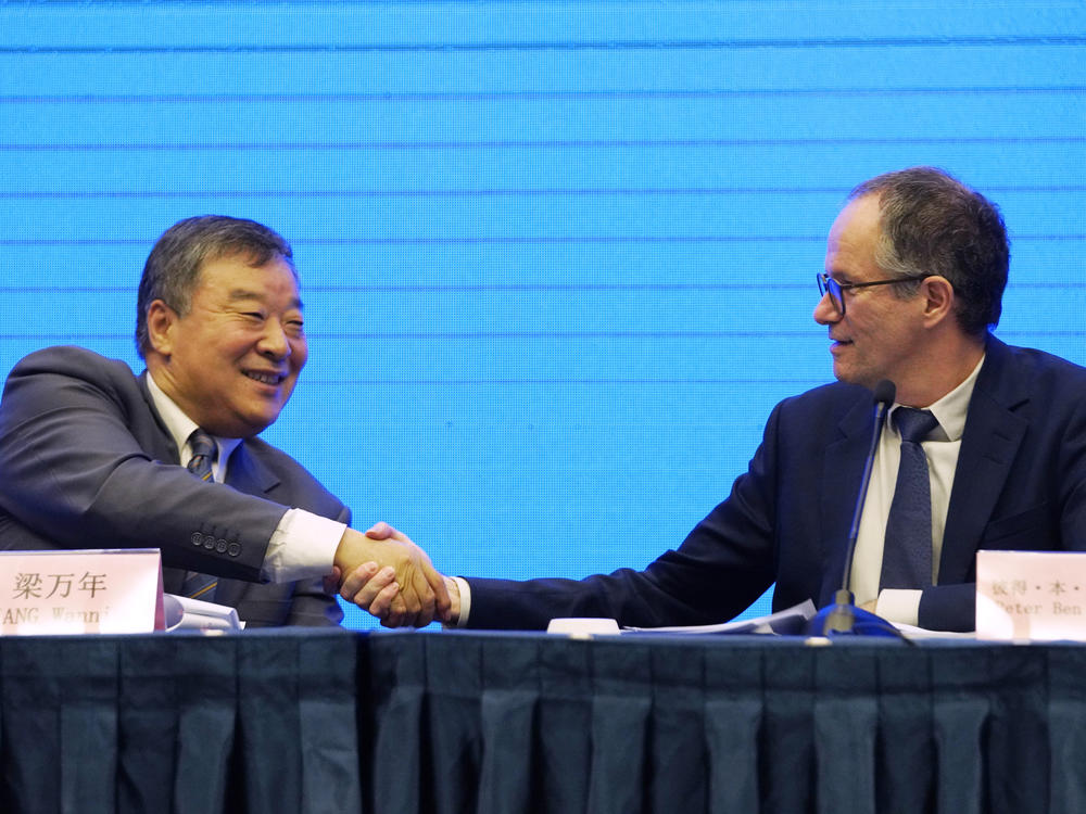 Peter Ben Embarek, of the World Health Organization team (right), shakes hands with Liang Wannian, his Chinese counterpart, after a news conference on Tuesday in Wuhan, China. The White House says it has 