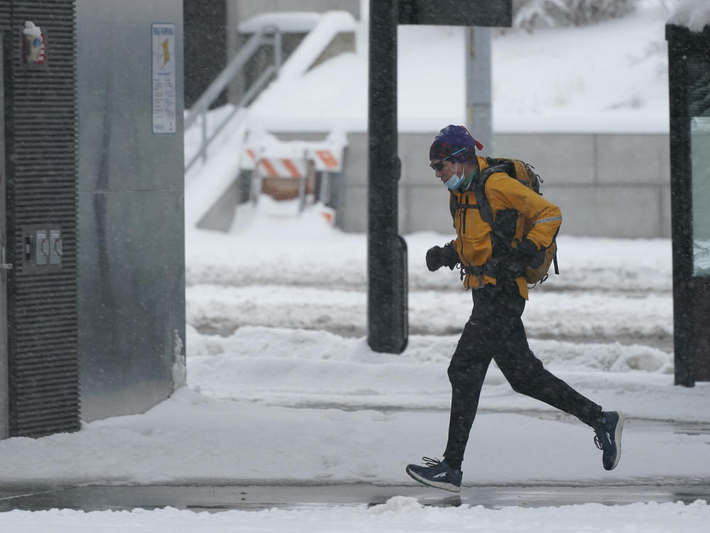 A person runs in the snow on Saturday on the University of Washington campus in Seattle. Winter weather was expected to continue through the weekend in the region. Winter conditions are forecast to extend through much of the U.S. early into the week.