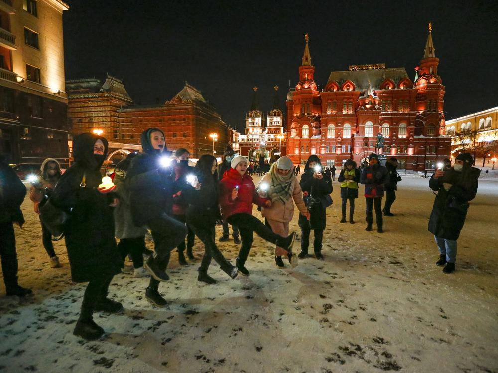 Young people dance shining their cellphone flashlights in support of jailed opposition leader Alexei Navalny and his wife Yulia Navalnaya near Red Square in Moscow on Sunday.