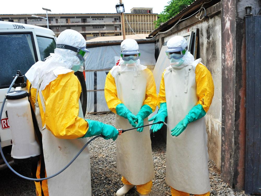 In a photo from Guinea's previous Ebola outbreak, medical staff clean their protection suits in March 2015 in Conakry, Guinea. Guinean authorities declared a new Ebola outbreak Sunday.