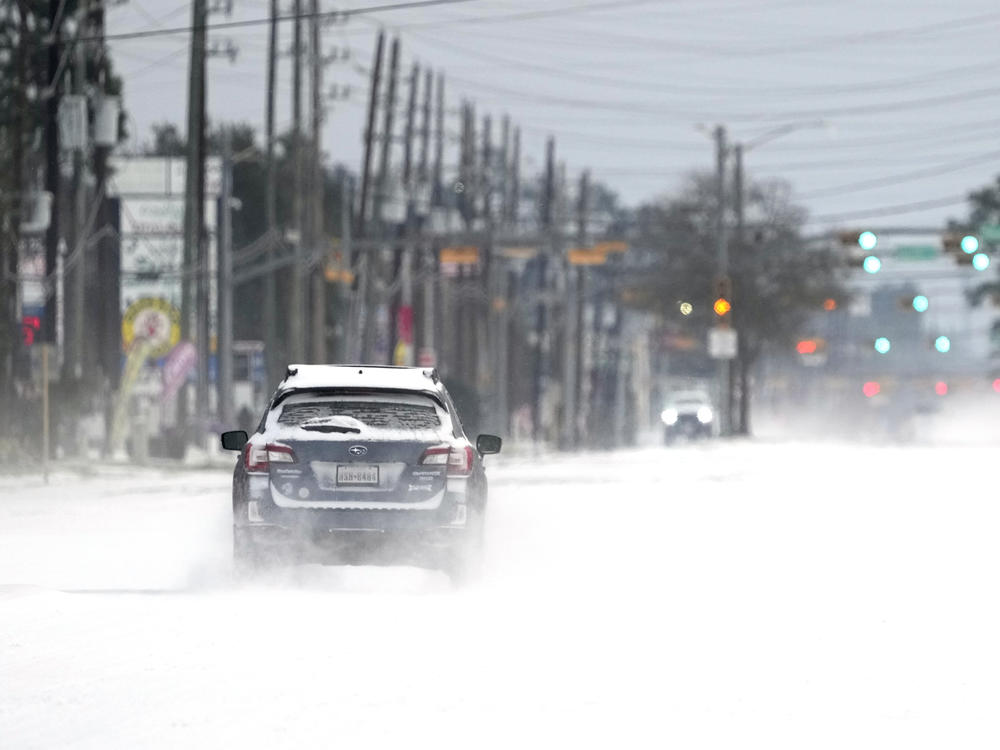 Vehicles drive on snow and sleet-covered roads Monday, in Spring, Texas. Texas Gov. Greg Abbott issued a disaster declaration in all of the state's 254 counties.