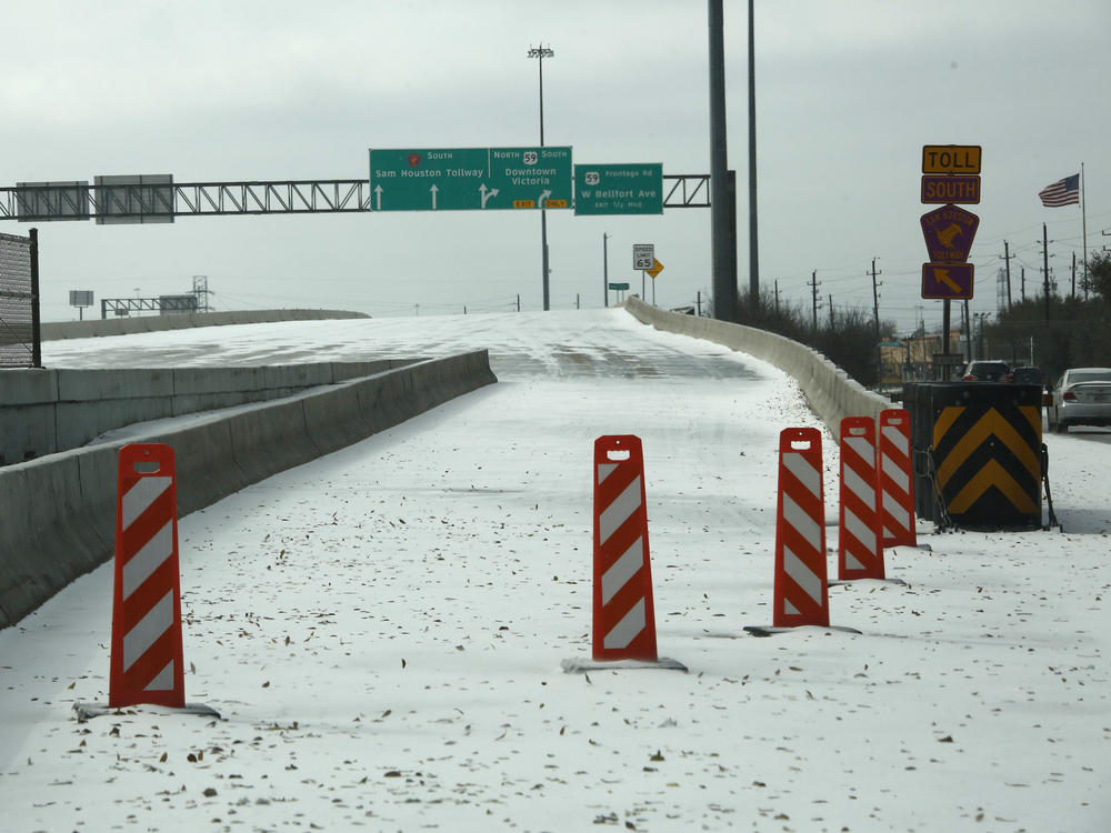 A highway on-ramp in Houston is closed due to snow and ice on Monday. Frigid temperatures, icy roads and power outages caused by a major winter storm have interfered with COVID-19 vaccine distribution in Texas and several other states.