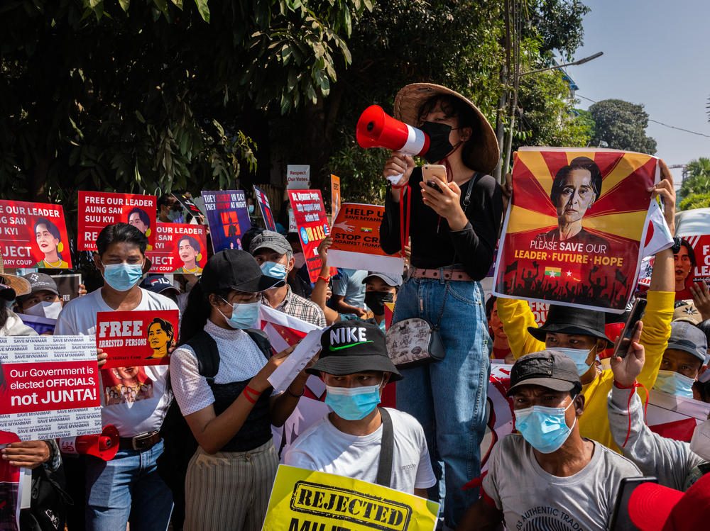 Protesters shout slogans and hold banners in front of the U.N. headquarters on Tuesday in Yangon, Myanmar, calling for the release of ousted leader Aung San Suu Kyi.
